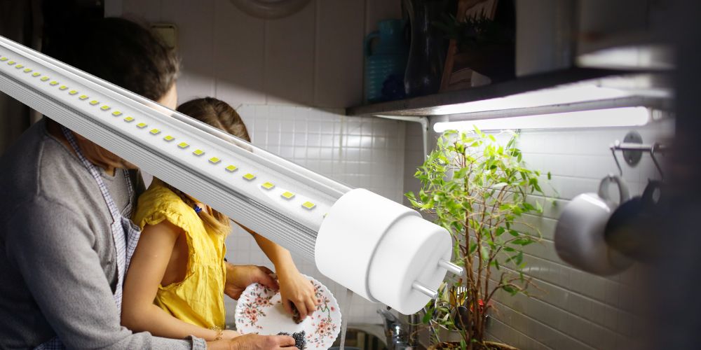 Cuisine avec pàre et fille lavant la vaisselle, mettant en avant un tube LED comme éclairage de plan de travail.