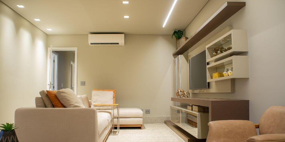 Sala de tv com downlights quadrados instalados no tecto