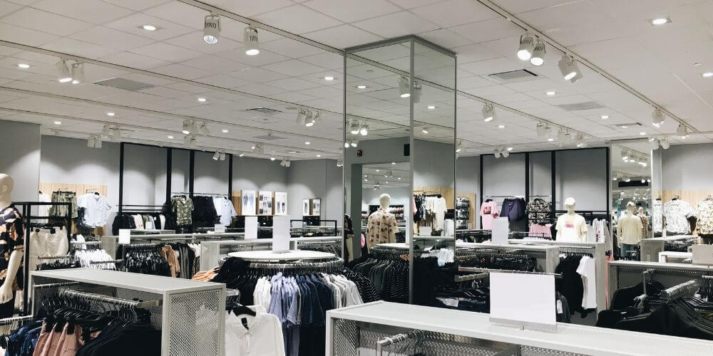 Loja de roupa iluminada com projetores de calha